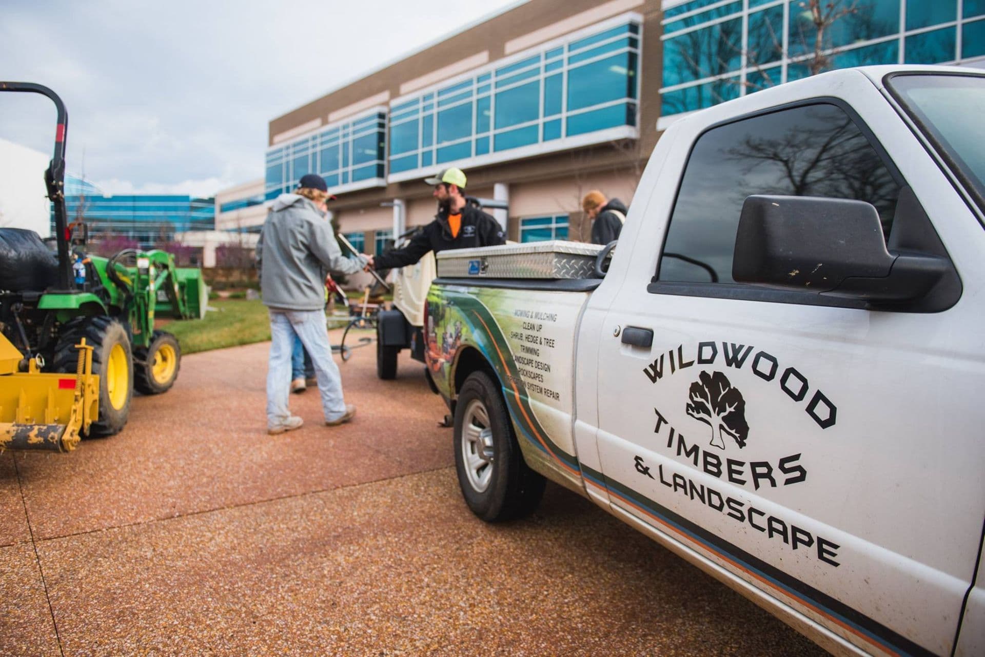 Wildwood Landscapes crew on-site with branded equipment at a commercial property.